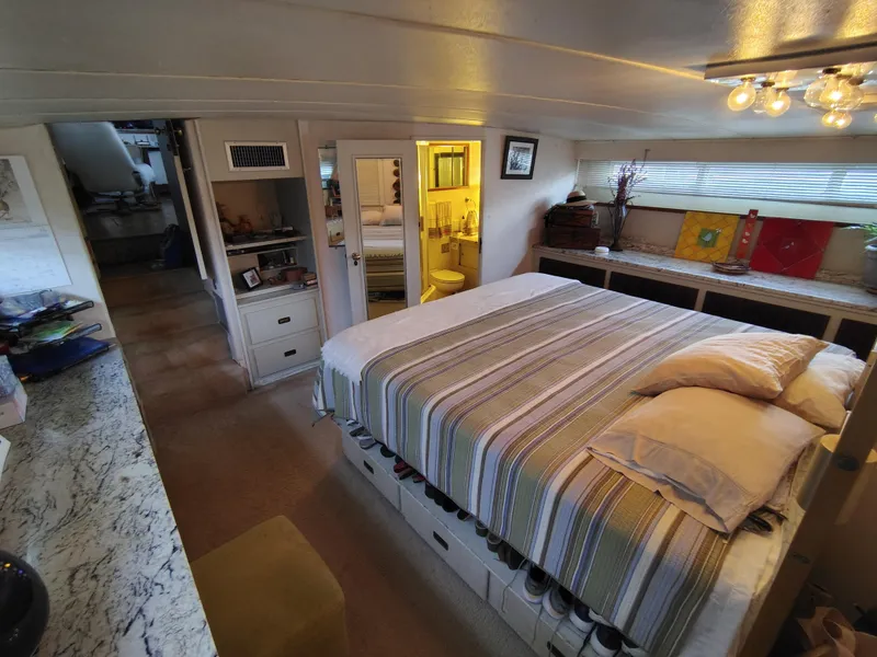 Slide: The Image of 1976 Bertram 58 Flybridge Motor Yacht bedroom with striped bedding and cozy decor. - 33