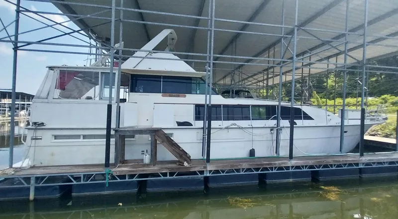 Slide: The Image of 1976 Bertram 58 Flybridge Motor Yacht docked under a covered marina. - 4