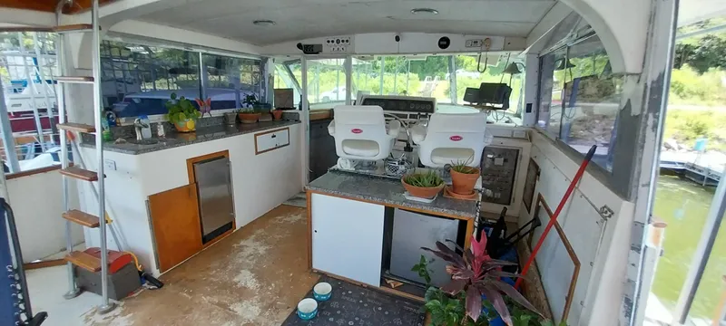 Slide: The Image of 1976 Bertram 58 Flybridge Motor Yacht interior with helm, seating, and plants. - 42