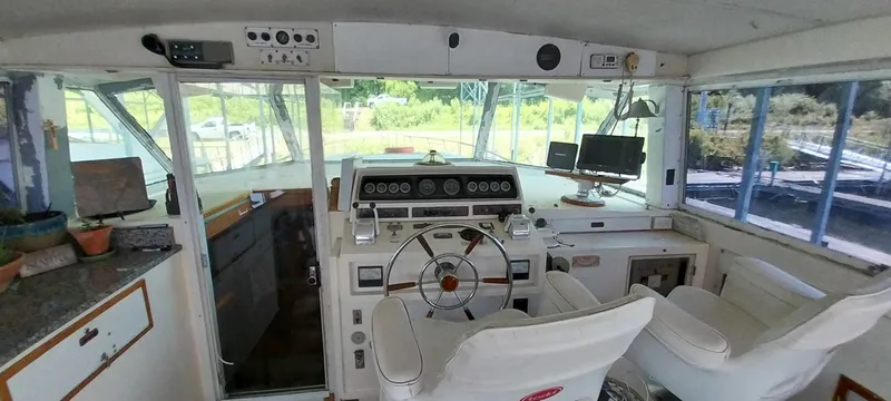 Slide: The Image of 1976 Bertram 58 Flybridge Motor Yacht helm with dual captain chairs and navigation equipment. - 47