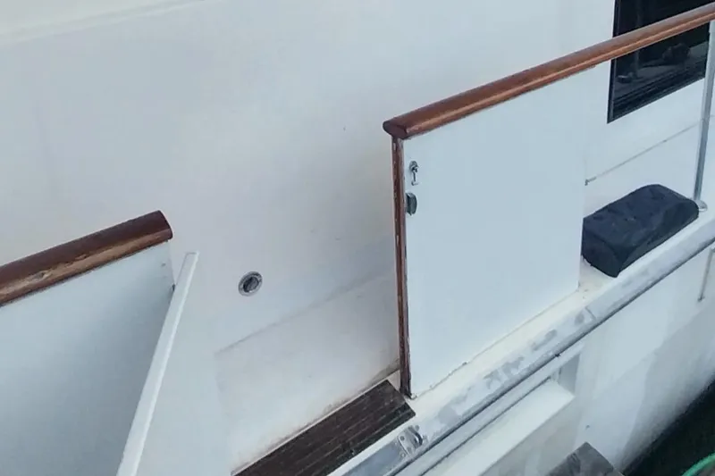 Slide: The Image of 1976 Bertram 58 Flybridge Motor Yacht side deck with wooden railings. - 5