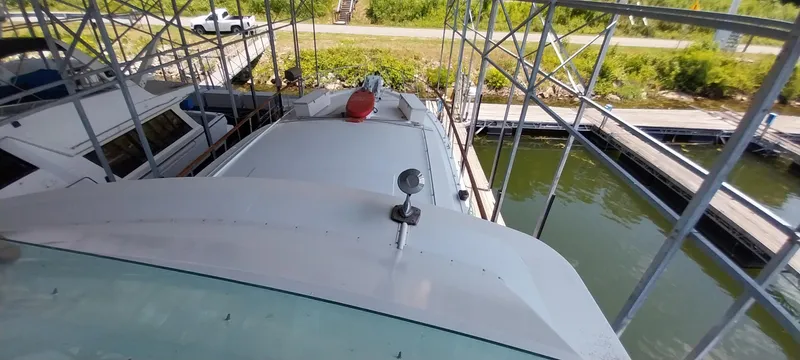 Slide: The Image of 1976 Bertram 58 Flybridge Motor Yacht docked in a covered marina. - 52