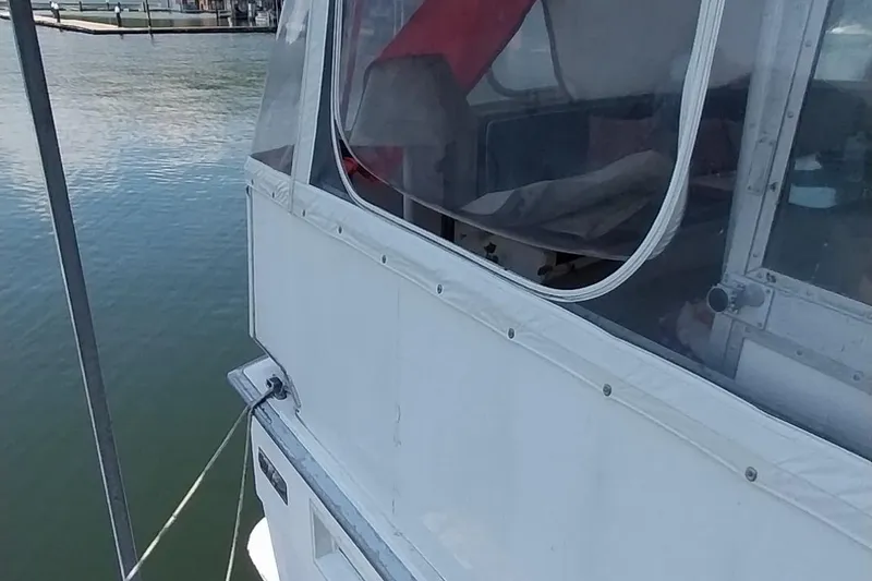 Slide: The Image of 1976 Bertram 58 Flybridge Motor Yacht docked, featuring side view and enclosed cabin. - 66