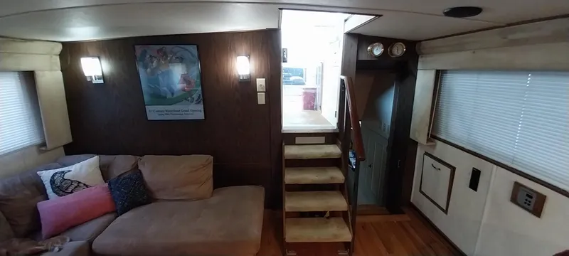 Slide: The Image of Interior of 1976 Bertram 58 Flybridge Motor Yacht with cozy seating area and stairs. - 7
