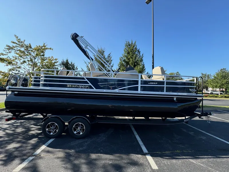 Slide: The Image of 2024 Ranger Reata 223F pontoon boat parked in sunny lot. - 1