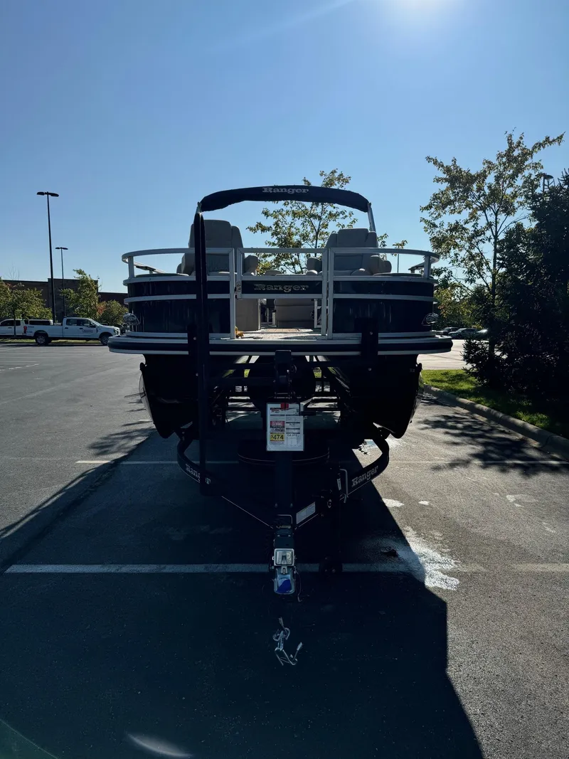 Slide: The Image of 2024 Ranger Reata 223F boat on trailer in parking lot, sunny day. - 2