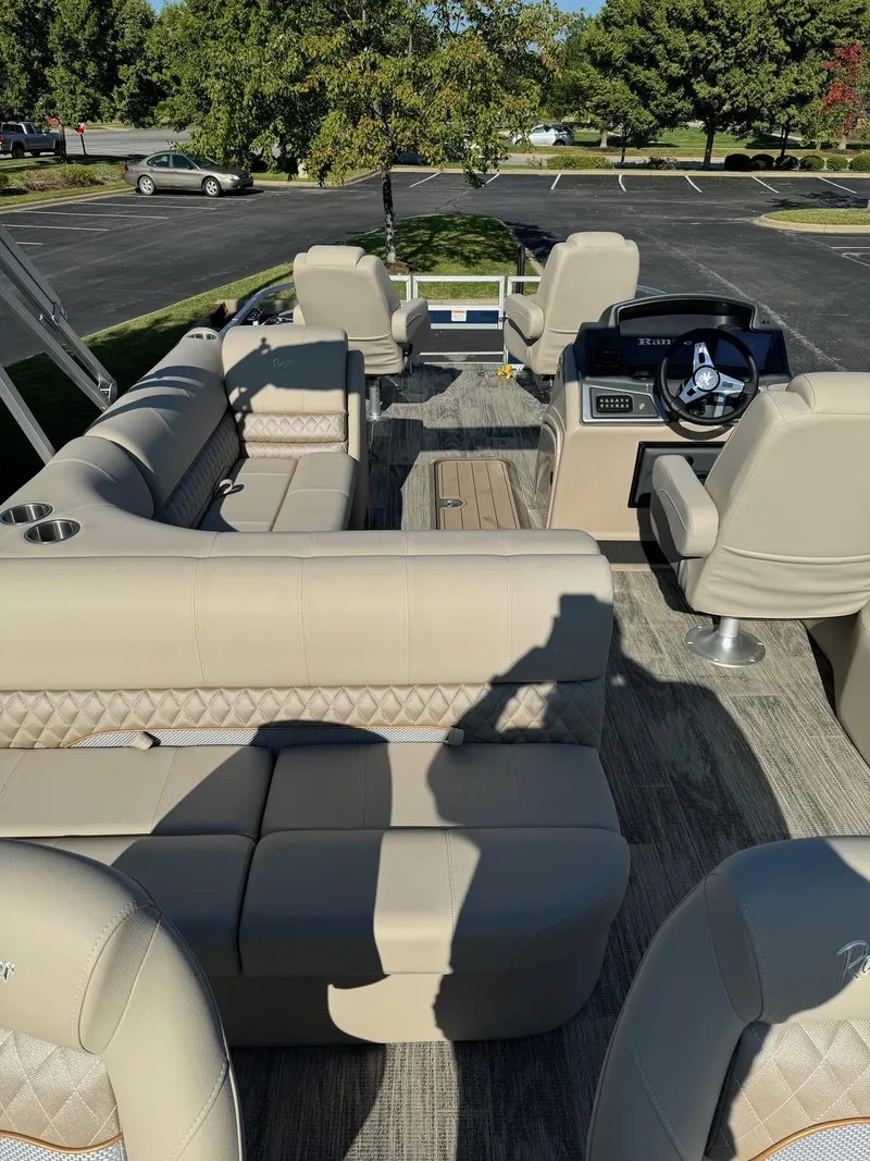 Slide: The Image of 2024 Ranger Reata 223F boat interior with beige seating and modern dashboard. - 3
