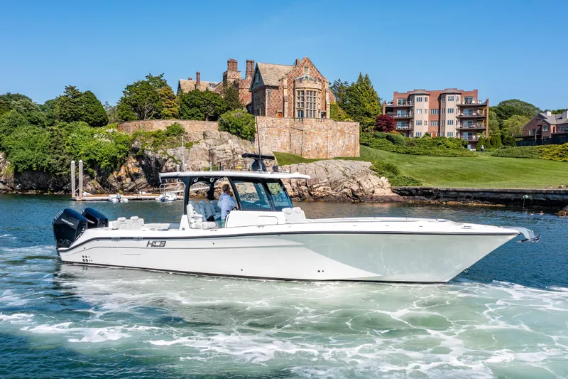 Slide: The Image of 2024 HCB 39 Speciale boat cruising near a historic waterfront estate. - 11