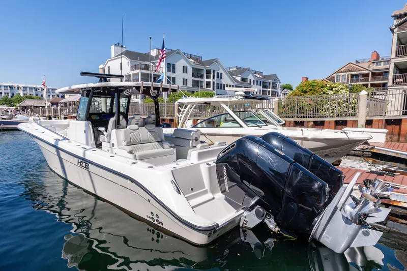 Slide: The Image of 2024 HCB 39 Speciale boat docked at a marina with waterfront buildings in the background. - 20