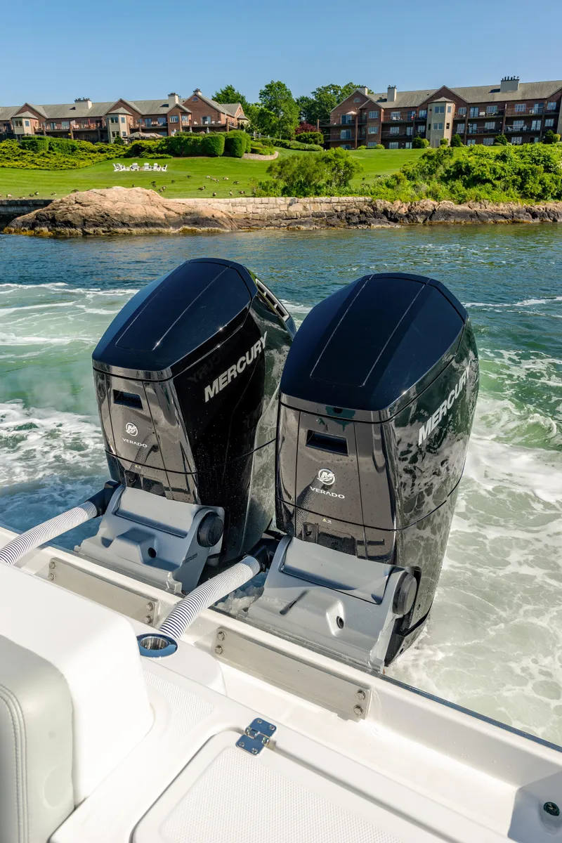 Slide: The Image of 2024 HCB 39 Speciale with twin Mercury outboard engines cruising near waterfront homes. - 32