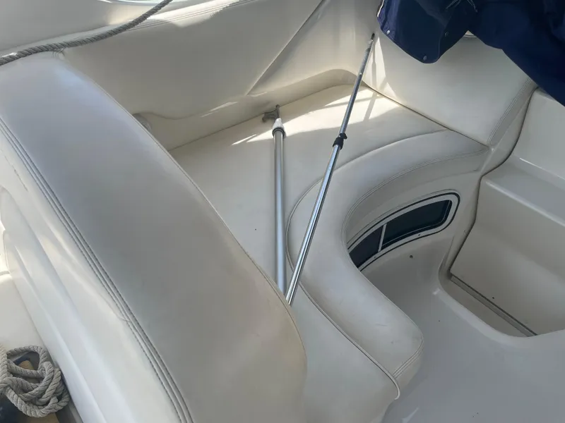 Slide: The Image of 2006 Sea Ray 280 Sundancer interior seating with white upholstery and storage compartment. - 22