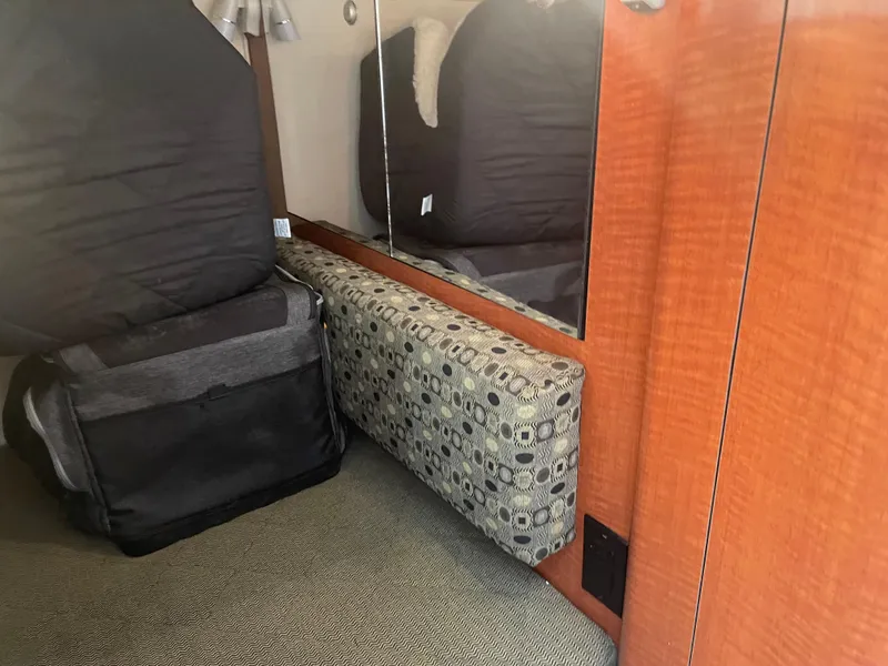 Slide: The Image of Interior of 2006 Sea Ray 280 Sundancer with patterned upholstery and wooden cabinetry. - 27