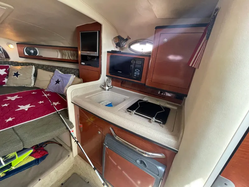 Slide: The Image of 2006 Sea Ray 280 Sundancer cabin with kitchenette and cozy sleeping area. - 30