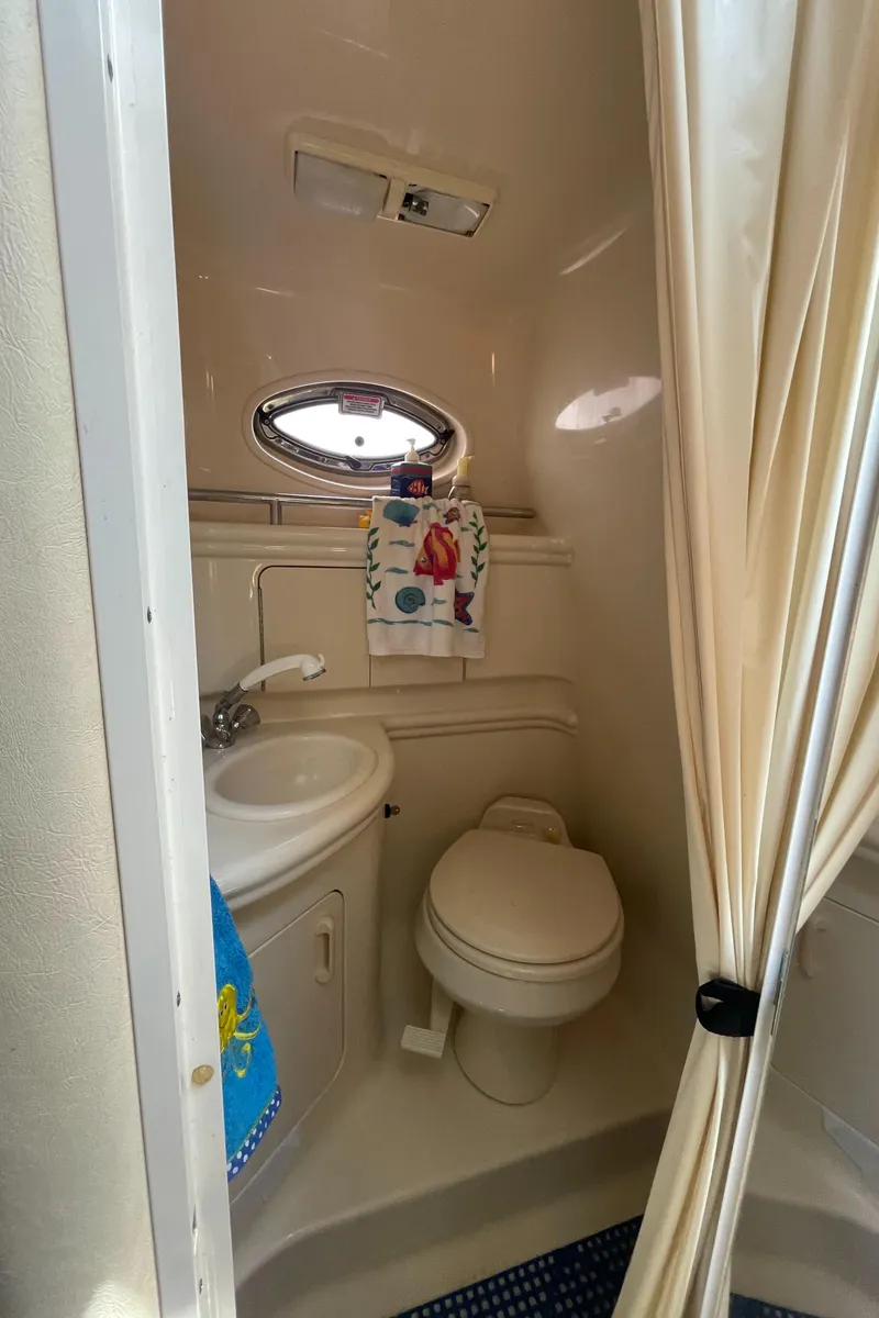 Slide: The Image of 2006 Sea Ray 280 Sundancer bathroom with sink, toilet, and porthole window. - 36