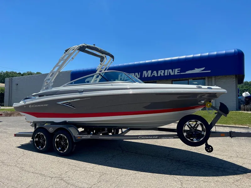 The Image of 2025 Crownline 220 SS boat on trailer outside marine dealership. - 0