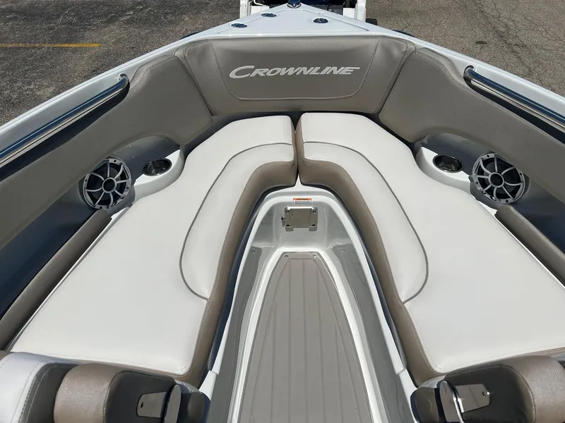 Slide: The Image of 2025 Crownline 220 SS boat interior with cushioned seating and built-in speakers. - 2