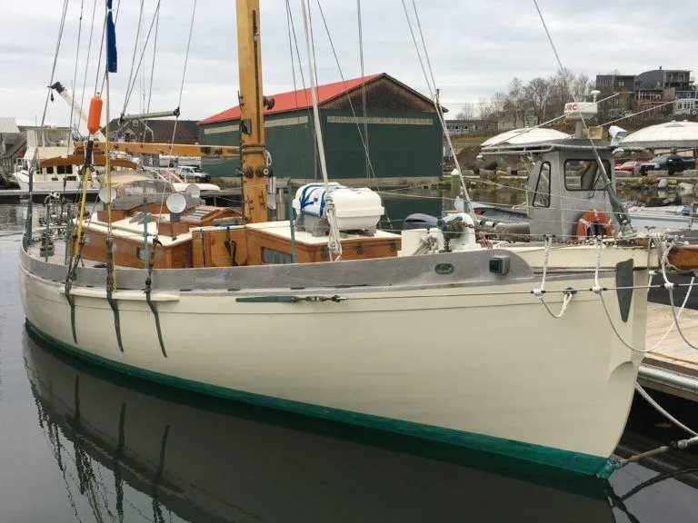 The Image of Custom 1999 Lyle Hess Cutter sailboat docked in a marina, featuring classic design elements. - 0