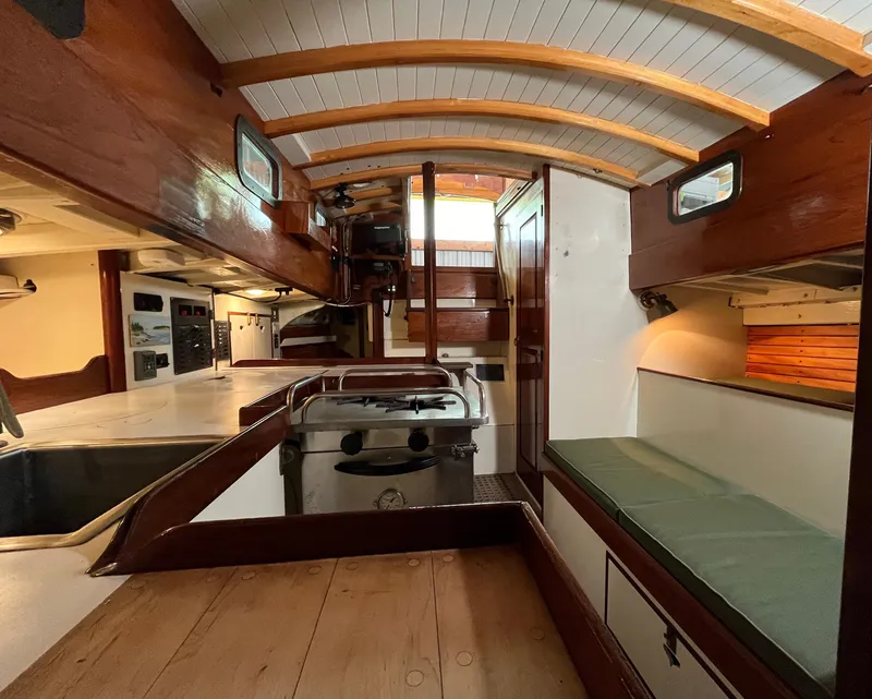 Slide: The Image of Interior of a 1999 Custom Lyle Hess Cutter sailboat, featuring wood finishes and compact design. - 12