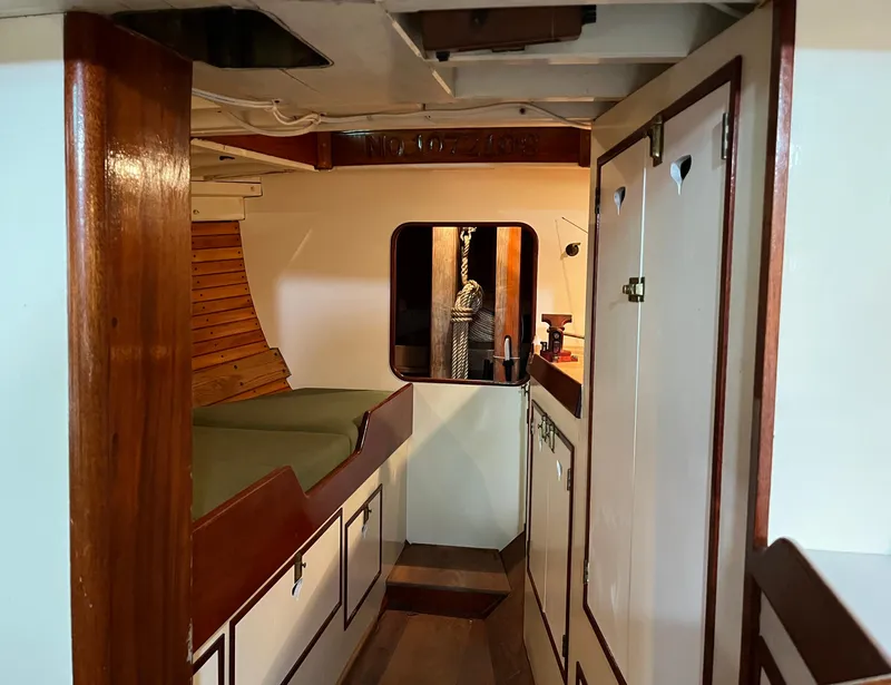 Slide: The Image of Interior of 1999 Custom Lyle Hess Cutter sailboat with wood accents and cozy cabin space. - 14