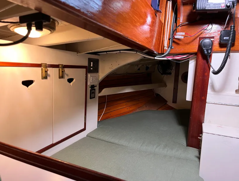 Slide: The Image of Cozy cabin interior of 1999 Custom Lyle Hess Cutter sailboat with wood accents and green bedding. - 17