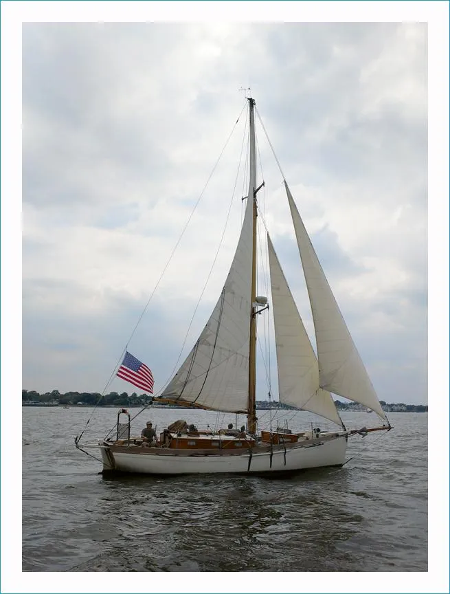Slide: The Image of Sailing on calm waters, a 1999 Custom Lyle Hess Cutter with American flag. - 2
