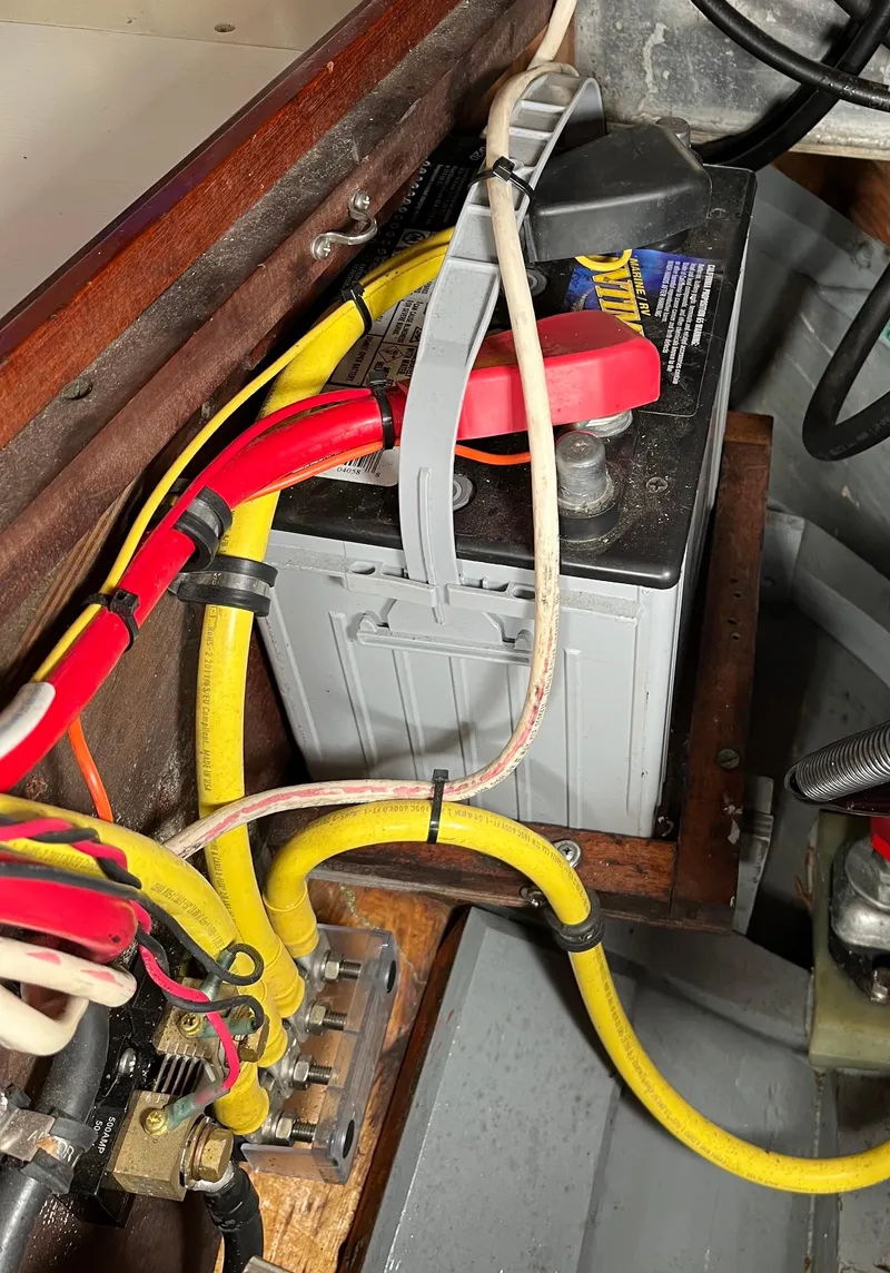 Slide: The Image of Battery setup in a 1999 Custom Lyle Hess Cutter boat with connected cables. - 23