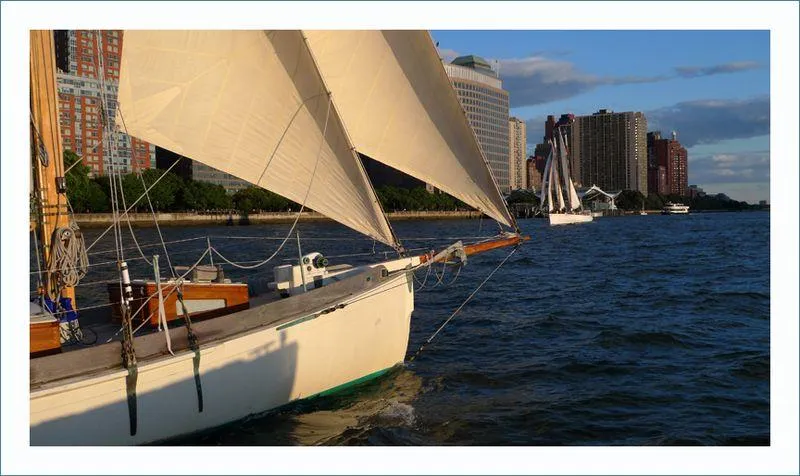 Slide: The Image of Sailboats on a river near city buildings, featuring a 1999 Custom Lyle Hess Cutter. - 4