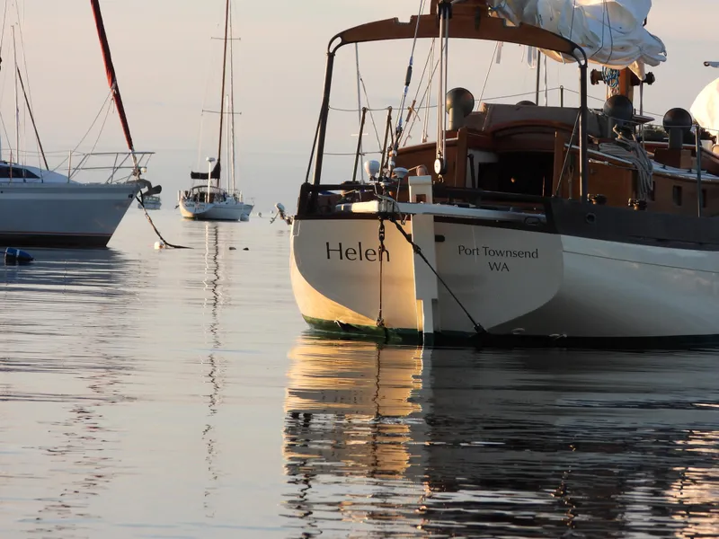 Slide: The Image of Sailboats anchored on calm water, featuring a 1999 Custom Lyle Hess Cutter named "Helen." - 7