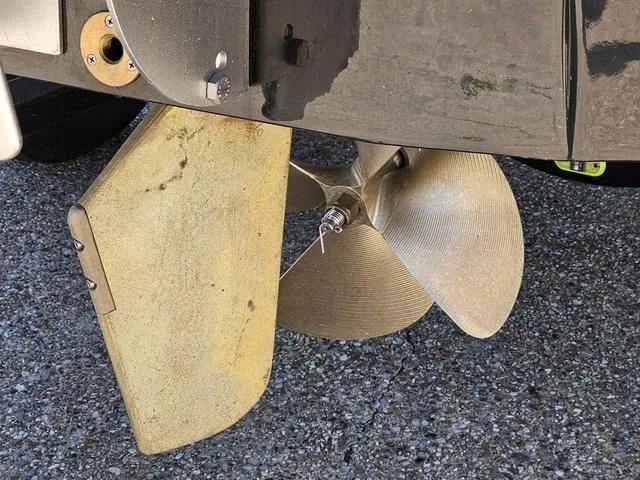 Slide: The Image of 2024 Axis Wake Research A225 boat propeller and rudder on a textured surface. - 12