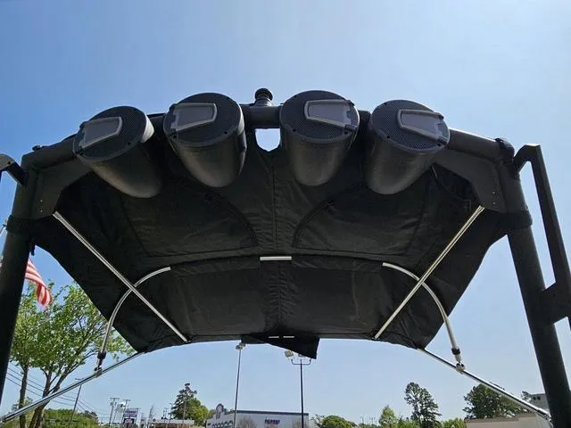 Slide: The Image of 2024 Axis Wake Research A225 boat speakers on a black canopy under clear sky. - 37