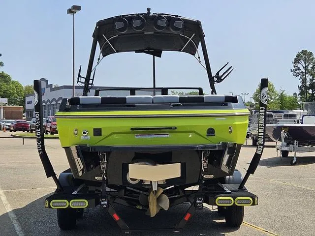 Slide: The Image of 2024 Axis Wake Research A225 boat, lime green, rear view in parking lot. - 4