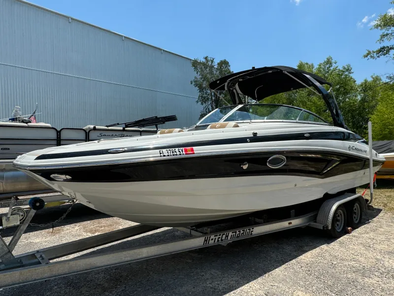 Slide: The Image of 2021 Crownline E275 XS boat on trailer, parked outdoors under clear sky. - 1