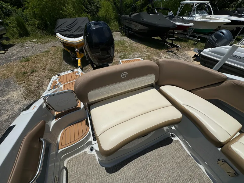 Slide: The Image of 2021 Crownline E275 XS boat interior with beige seating and wood accents. - 11
