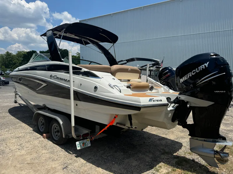 Slide: The Image of 2021 Crownline E275 XS boat on trailer with Mercury outboard motor, parked outdoors. - 13