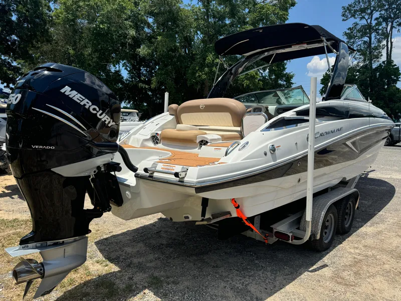Slide: The Image of 2021 Crownline E275 XS boat on trailer with Mercury engine, parked outdoors. - 14