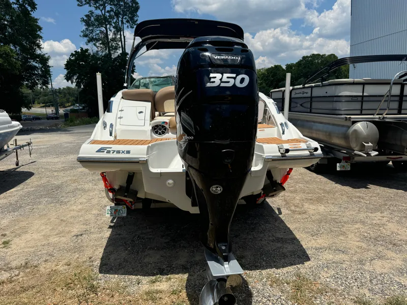 Slide: The Image of 2021 Crownline E275 XS boat with powerful 350 Verado engine, parked outdoors. - 2