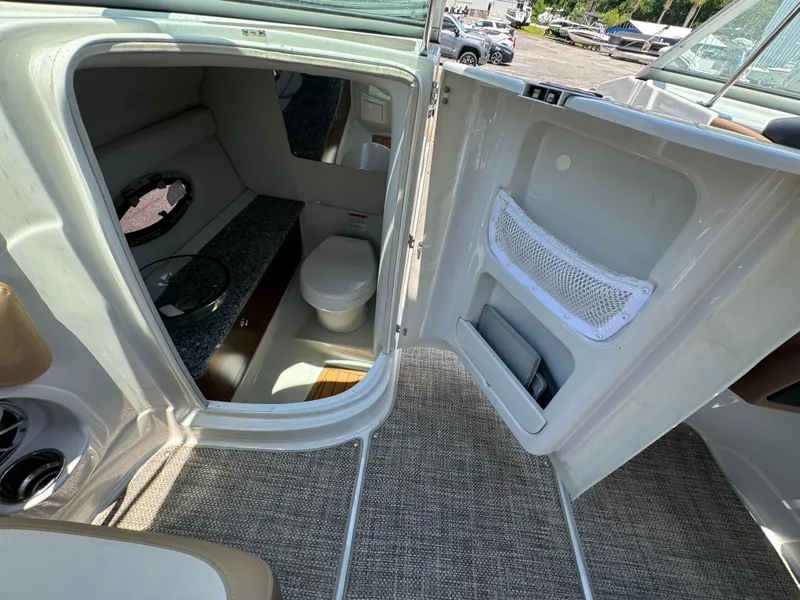 Slide: The Image of 2021 Crownline E275 XS boat interior with bathroom and storage compartment. - 5