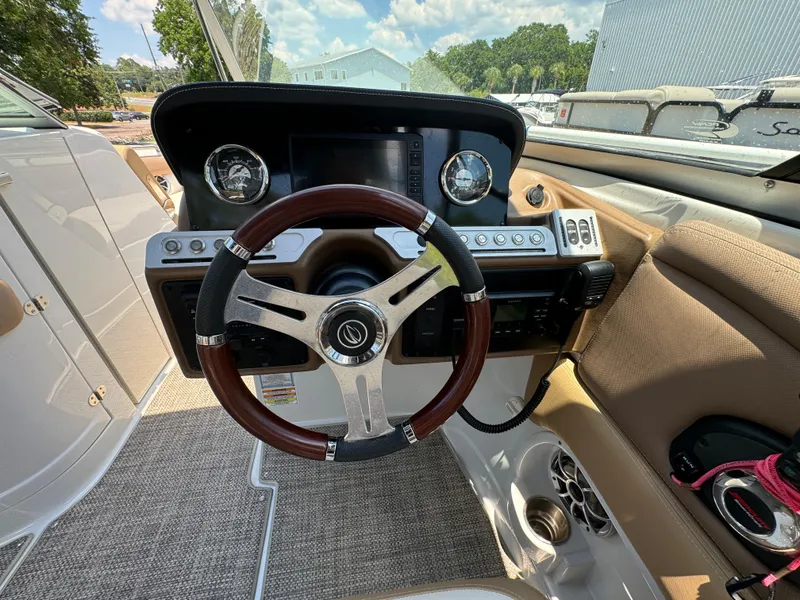 Slide: The Image of 2021 Crownline E275 XS boat dashboard with steering wheel and control panel. - 7