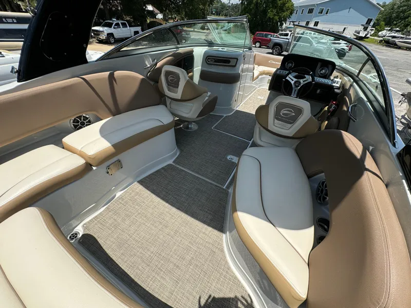 Slide: The Image of 2021 Crownline E275 XS boat interior with beige seating and modern dashboard. - 8