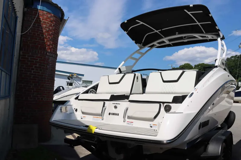 Slide: The Image of 2024 Yamaha Boats 252SD, white luxury boat with black accents, docked outdoors. - 16
