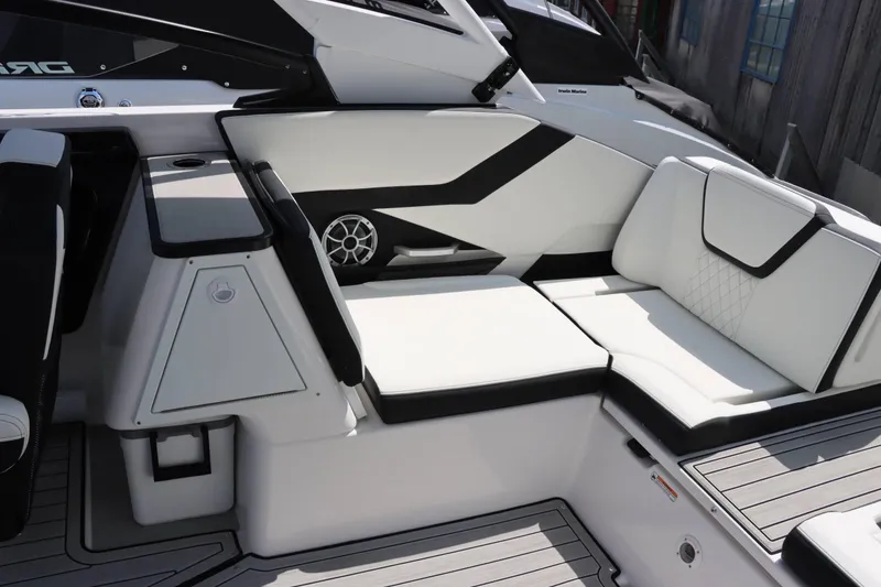 Slide: The Image of Interior seating of 2024 Yamaha Boats 252SD, featuring white and black upholstery with integrated speaker. - 8