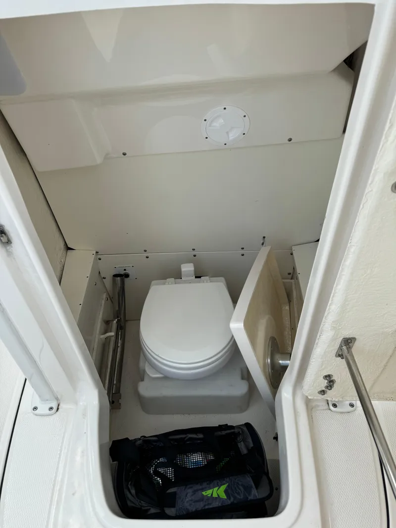 Slide: The Image of 2023 Robalo R230 Center Console boat interior with marine toilet. - 11