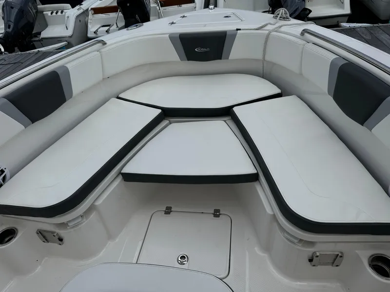 Slide: The Image of 2023 Robalo R230 Center Console boat with cushioned seating area. - 12