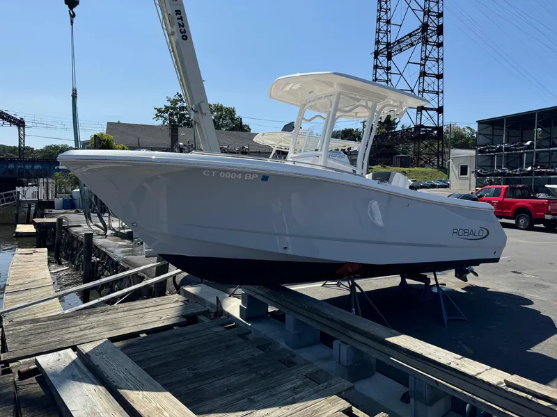 Slide: The Image of 2023 Robalo R230 Center Console boat on a dock, side view. - 16
