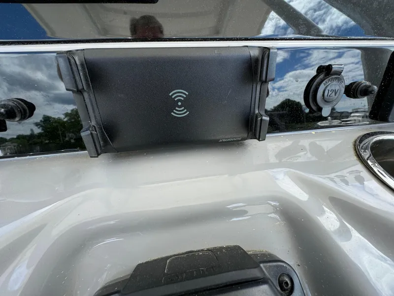 Slide: The Image of 2023 Robalo R230 Center Console dashboard with wireless charging pad and 12V outlet. - 8