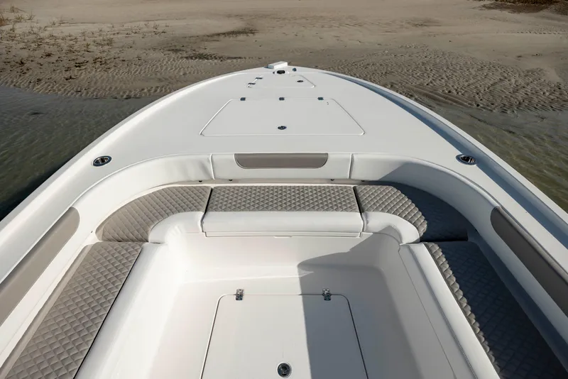 Slide: The Image of 2024 Caymas 281 HB boat bow with cushioned seating and storage compartments. - 10