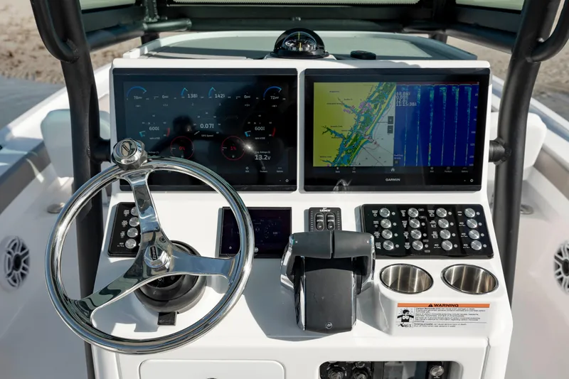 Slide: The Image of 2024 Caymas 281 HB boat dashboard with dual screens and steering wheel. - 17