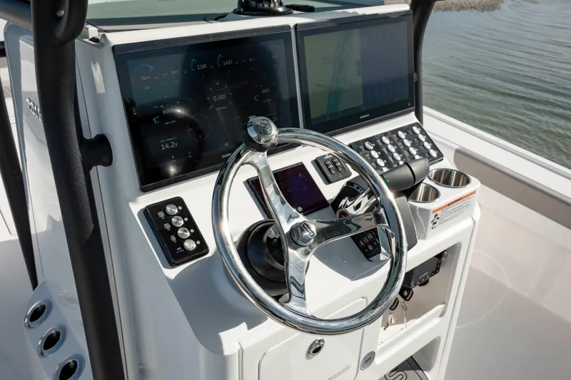 Slide: The Image of 2024 Caymas 281 HB boat dashboard with dual screens and chrome steering wheel. - 18