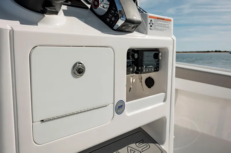 Slide: The Image of 2024 Caymas 281 HB boat dashboard with storage compartment and control panel. - 19