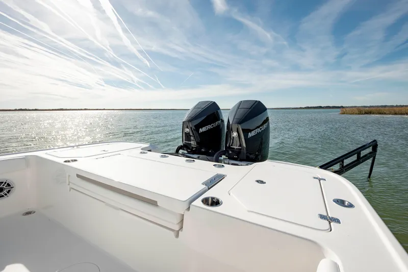 Slide: The Image of 2024 Caymas 281 HB boat with dual Mercury engines on a serene lake. - 23